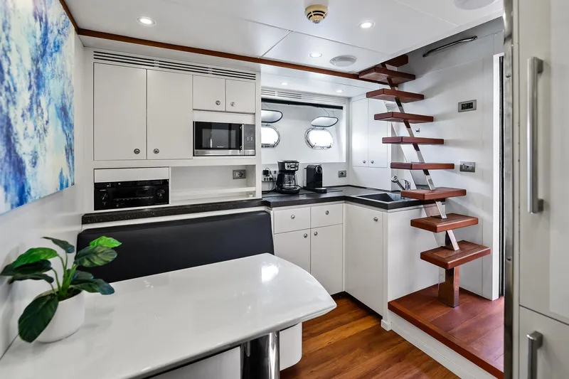 Diamond Yacht Photos Pics Modern kitchen interior on 2013 AB 116 Motoryacht with sleek cabinetry and wooden stairs.