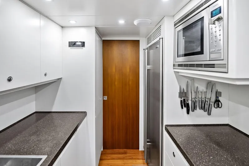 Diamond Yacht Photos Pics Modern galley kitchen on 2013 AB 116 Motoryacht with sleek countertops and stainless steel appliances.