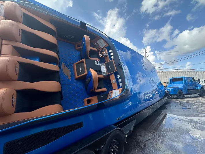  Yacht Photos Pics Blue Skater 46 boat interior with tan seats, 2013 model, parked outdoors under a cloudy sky.