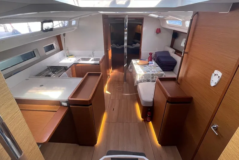 Cicerenella Yacht Photos Pics Interior of 2019 Jeanneau Sun Odyssey 440 yacht, featuring modern kitchen and cozy seating area.