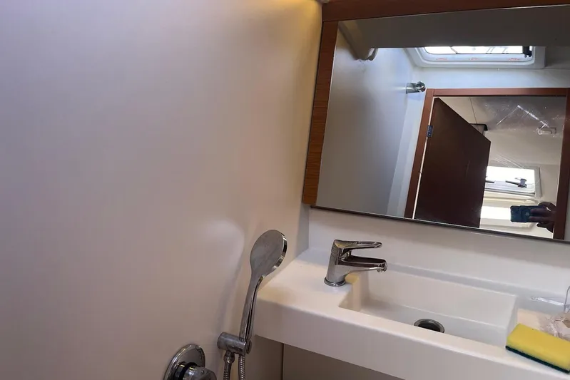 Cicerenella Yacht Photos Pics Bathroom interior of 2019 Jeanneau Sun Odyssey 440 yacht, featuring sink and mirror.