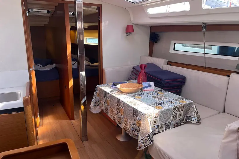 Cicerenella Yacht Photos Pics Interior of 2019 Jeanneau Sun Odyssey 440 yacht with cozy seating and dining area.