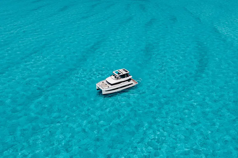Libert'e Yacht Photos Pics 2020 Fountaine Pajot MY6 yacht on clear turquoise water, aerial view.