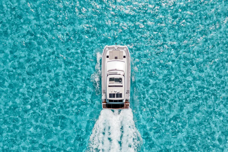 Libert'e Yacht Photos Pics Aerial view of 2020 Fountaine Pajot MY6 yacht cruising in clear turquoise waters.