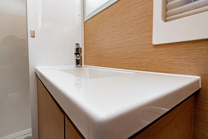 Libert'e Yacht Photos Pics Modern bathroom sink in 2020 Fountaine Pajot MY6 yacht, featuring sleek design and wood accents.