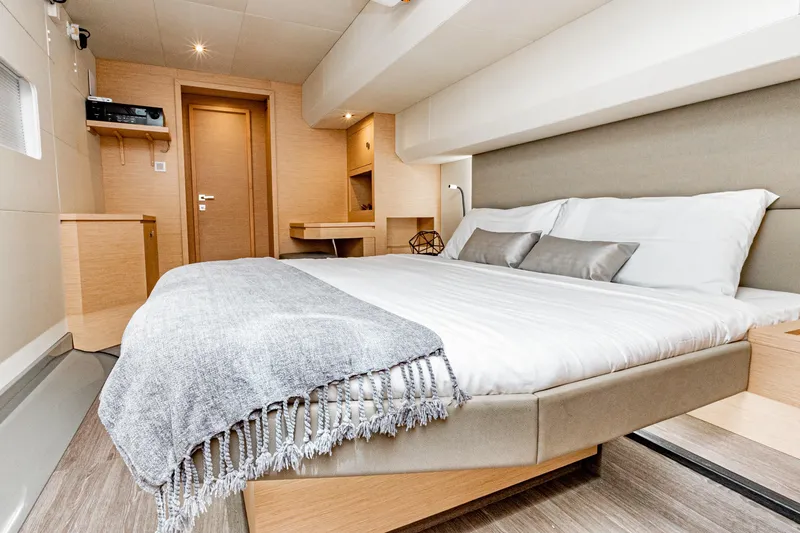Libert'e Yacht Photos Pics Luxurious bedroom interior of 2020 Fountaine Pajot MY6 yacht with modern design and cozy bedding.