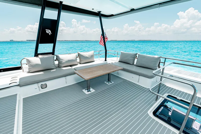 Libert'e Yacht Photos Pics Luxurious 2020 Fountaine Pajot MY6 yacht deck with seating, table, and ocean view.