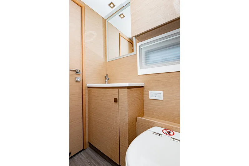 Libert'e Yacht Photos Pics Modern bathroom interior on 2020 Fountaine Pajot MY6 yacht, featuring sleek wood finishes.