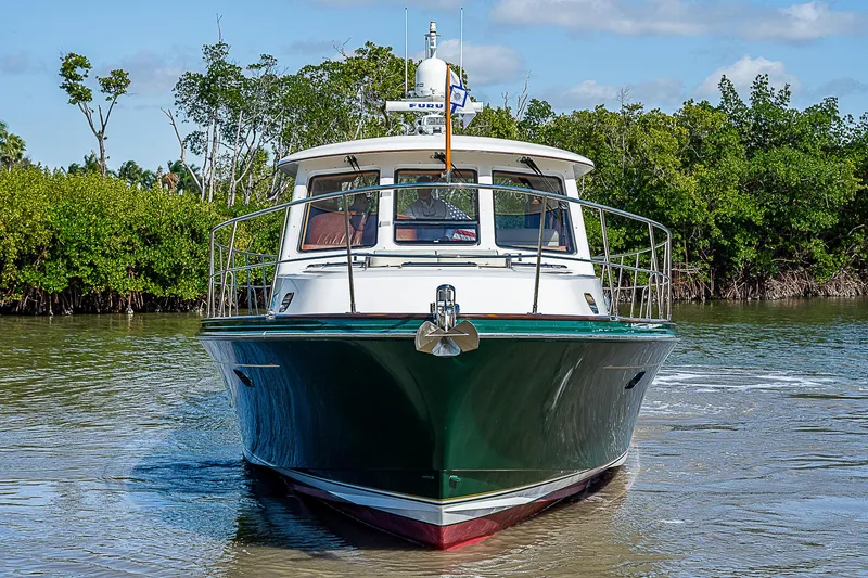 Marika Yacht Photos Pics 2011 Hunt Yachts 52 cruising on a calm river with lush greenery in the background.