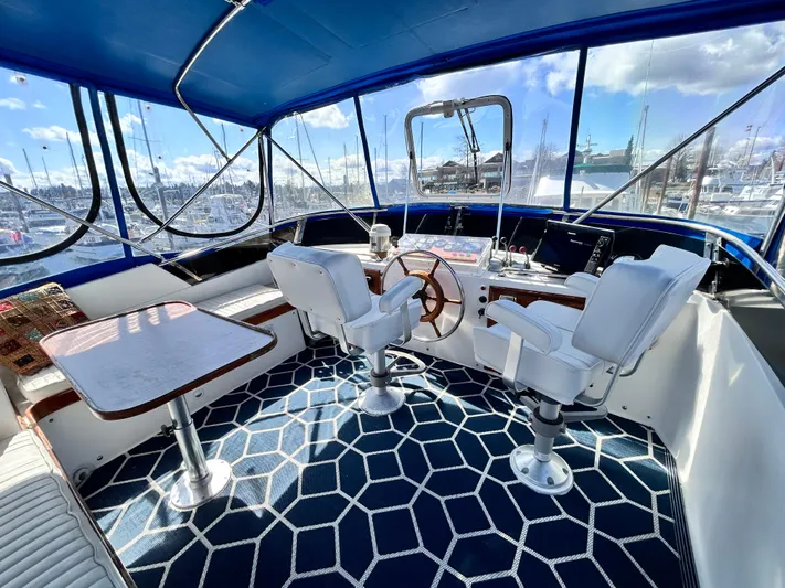  Yacht Photos Pics 1987 Marine Trader 44 Sunbridge Trawler helm with blue canopy and geometric carpet design.