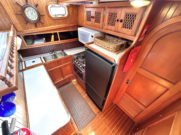 Yacht Photos Pics 1987 Marine Trader 44 Sunbridge Trawler kitchen with wood cabinetry, stove, and refrigerator.