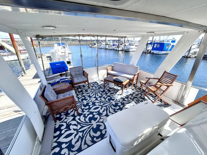  Yacht Photos Pics 1987 Marine Trader 44 Sunbridge Trawler deck with seating, patterned rug, and marina view.