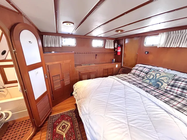  Yacht Photos Pics 1987 Marine Trader 44 Sunbridge Trawler cabin with cozy bed, wooden interior, and nautical decor.