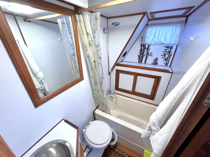  Yacht Photos Pics 1987 Marine Trader 44 Sunbridge Trawler bathroom with shower, sink, and decorative window.