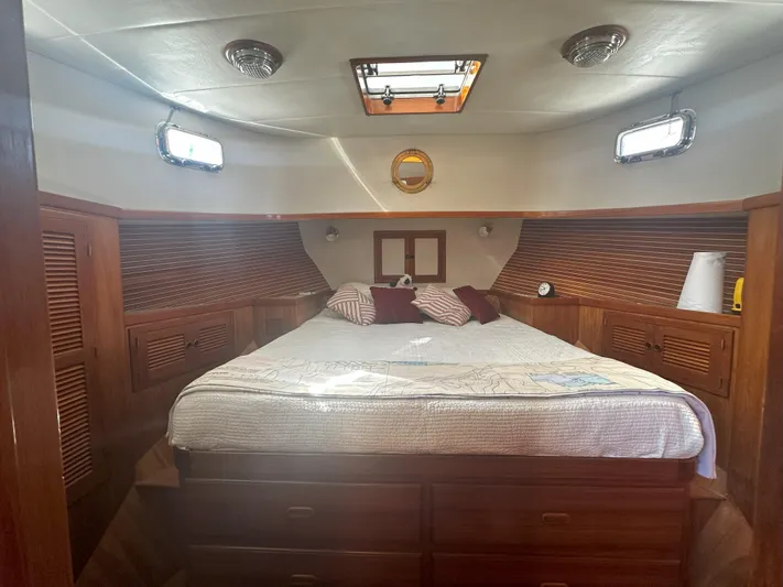 Brut Yacht Photos Pics Cozy bedroom in 1999 Krogen Trawler with wooden accents and natural light.