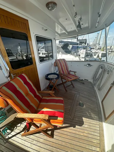 Brut Yacht Photos Pics 1999 Krogen Trawler deck with striped chairs and marina view.