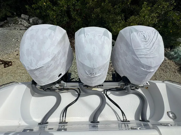  Yacht Photos Pics Triple outboard motors covered, Everglades 355 Tournament boat, 2016 model, docked near foliage.