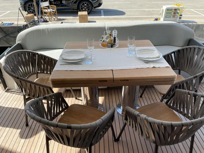  Yacht Photos Pics Outdoor dining setup on 2022 Cranchi Settantotto 78 yacht, featuring elegant table and chairs.