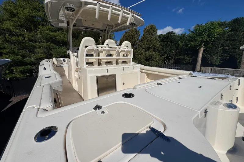  Yacht Photos Pics 2022 Grady-White Canyon 326 boat with spacious deck and seating, surrounded by trees.