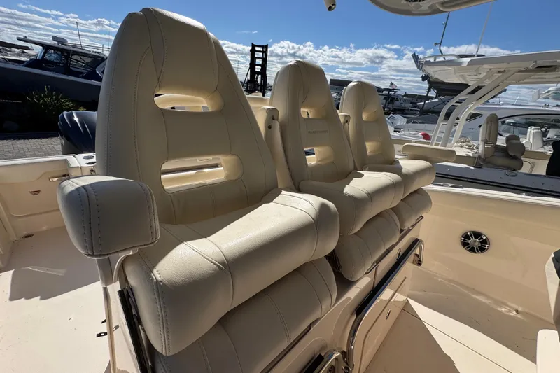  Yacht Photos Pics 2022 Grady-White Canyon 326 boat with luxurious beige seating in a marina setting.