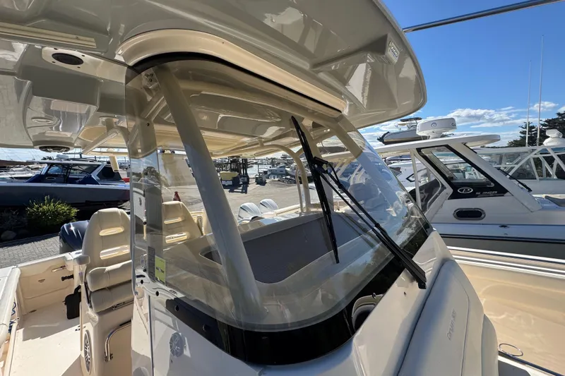  Yacht Photos Pics 2022 Grady-White Canyon 326 boat interior with seating and windshield, docked under clear skies.