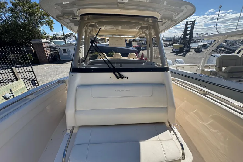  Yacht Photos Pics 2022 Grady-White Canyon 326 boat interior with seating and windshield, docked outdoors.