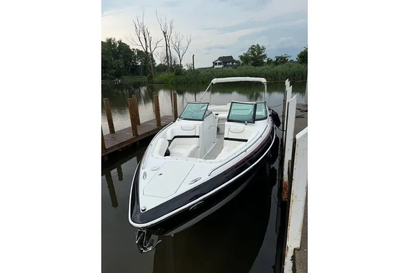  Yacht Photos Pics 2014 Formula 310 Bowrider docked on a calm lake with lush greenery.