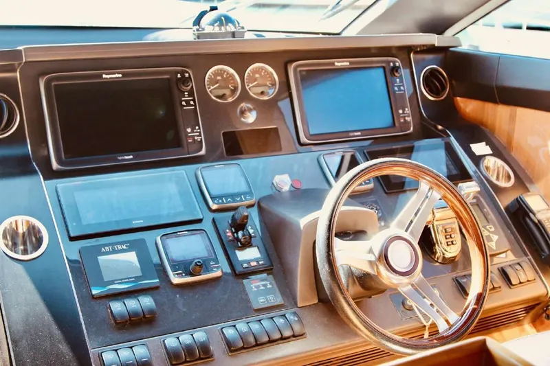  Yacht Photos Pics Control panel of a 2014 Princess 82 yacht with navigation screens and steering wheel.