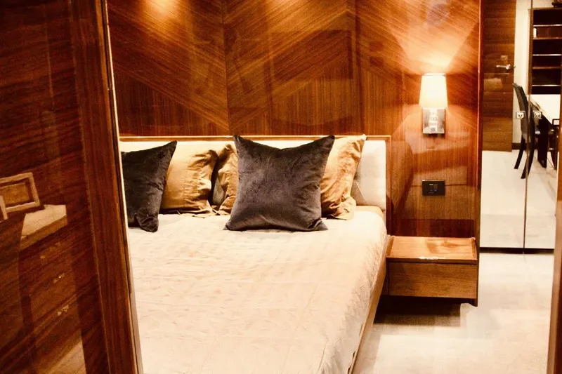  Yacht Photos Pics Luxurious bedroom interior on a 2014 Princess 82 yacht, featuring elegant wood paneling and plush bedding.