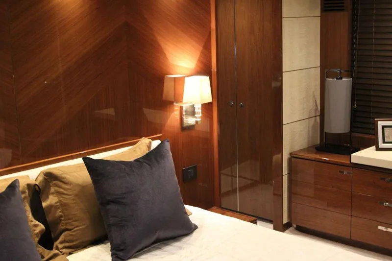  Yacht Photos Pics Luxurious bedroom interior on 2014 Princess 82 yacht, featuring elegant wood paneling and plush pillows.