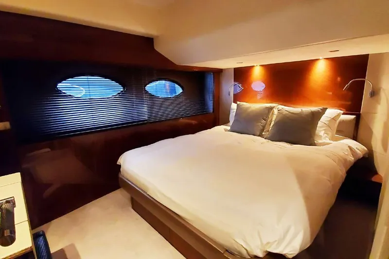  Yacht Photos Pics Luxurious bedroom interior of 2014 Princess 82 yacht with cozy lighting and elegant decor.
