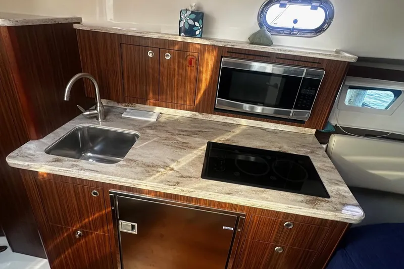  Yacht Photos Pics 2018 Pursuit OS 355 Offshore yacht kitchen with sink, microwave, and stovetop.