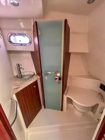  Yacht Photos Pics 2018 Pursuit OS 355 Offshore bathroom with glass sink and compact toilet.