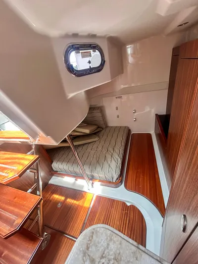  Yacht Photos Pics 2018 Pursuit OS 355 Offshore cabin interior with wood finish and compact bed.