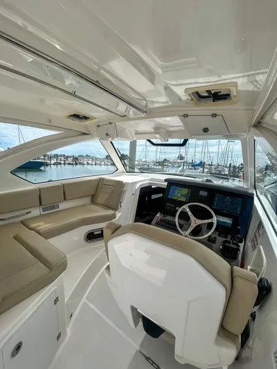  Yacht Photos Pics 2018 Pursuit OS 355 Offshore boat interior with helm, seating, and marina view.