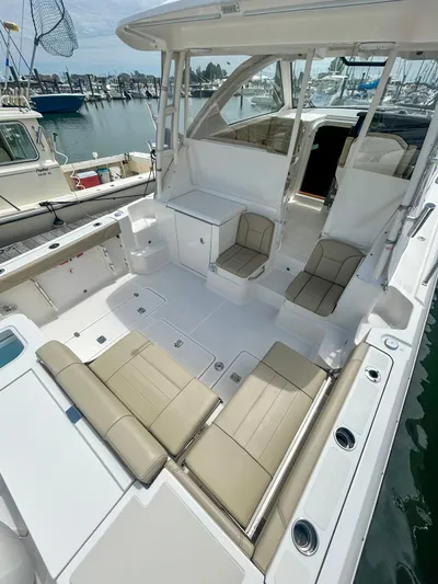  Yacht Photos Pics 2018 Pursuit OS 355 Offshore boat with spacious seating and sleek design at a marina.