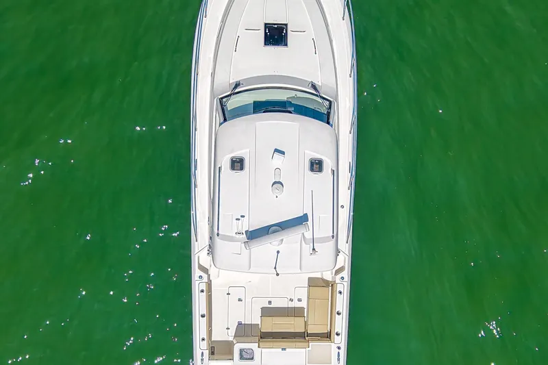  Yacht Photos Pics 2018 Pursuit OS 355 Offshore boat, aerial view, on vibrant green water.