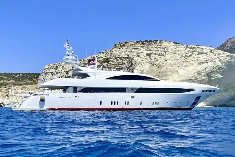 Mondomarine 138' Yacht Photos Pics Luxurious 2008 Mondomarine 138 yacht cruising near rocky coastline under clear blue sky.