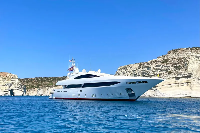 Mondomarine 138' Yacht Photos Pics Luxurious 2008 Mondomarine 138 yacht cruising near rocky coastline under clear blue sky.