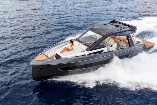  Yacht Photos Pics 2025 Schaefer V44 yacht cruising on open water with a person relaxing on deck.