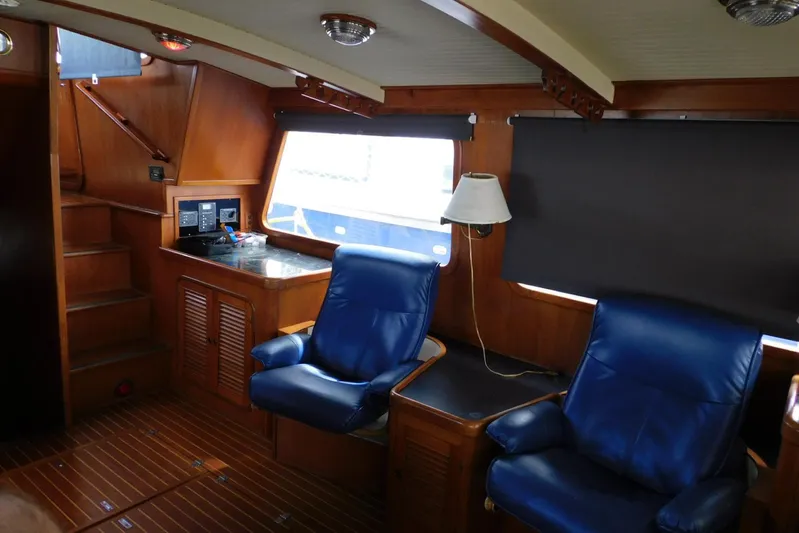 Popeye Yacht Photos Pics Interior of 1988 Hans Christian 45 Independence Trawler with blue leather chairs and wooden accents.