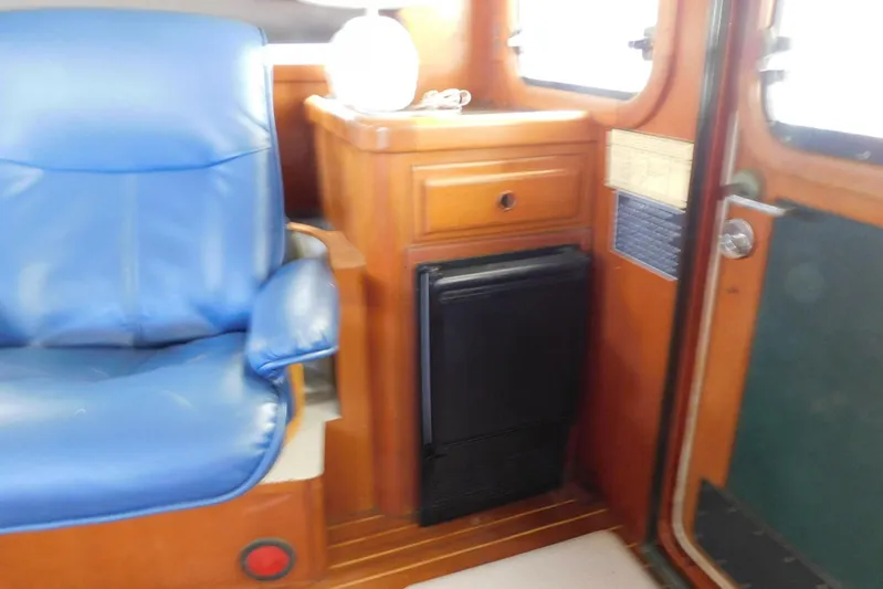 Popeye Yacht Photos Pics 1988 Hans Christian 45 Independence Trawler interior with blue seat and wooden cabinetry.