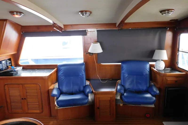 Popeye Yacht Photos Pics Interior of 1988 Hans Christian 45 Independence Trawler with blue leather chairs and wooden accents.