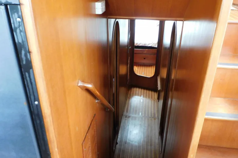 Popeye Yacht Photos Pics Narrow wooden hallway inside 1988 Hans Christian 45 Independence Trawler, featuring steps and cabin entrance.