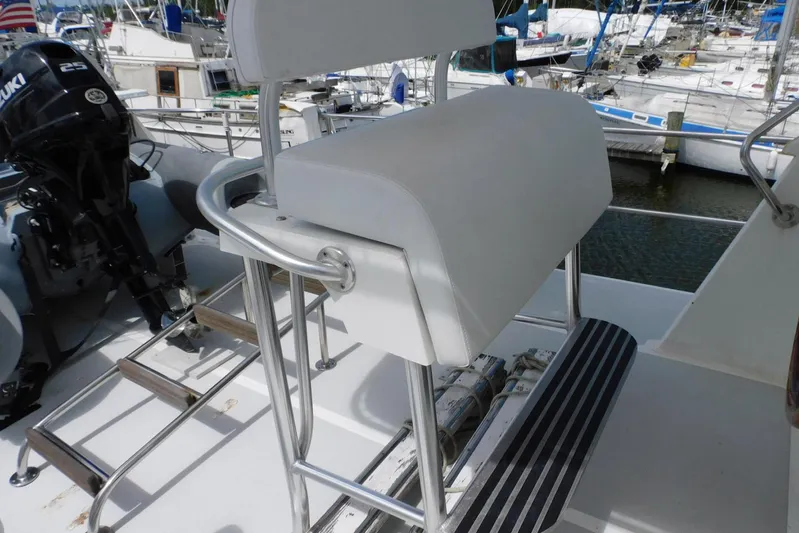 Popeye Yacht Photos Pics Captain's chair on 1988 Hans Christian 45 Independence Trawler, docked with visible Suzuki outboard motor.