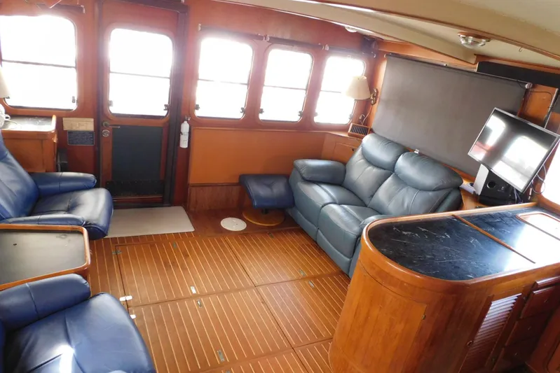 Popeye Yacht Photos Pics Interior of 1988 Hans Christian 45 Independence Trawler with blue leather seating and wooden flooring.