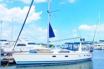 1997 Hunter 430 sailboat docked at marina under clear blue sky.