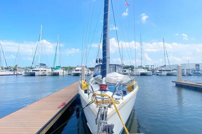 Hunter 430 sailboat from 1997 docked at a marina under a clear blue sky.