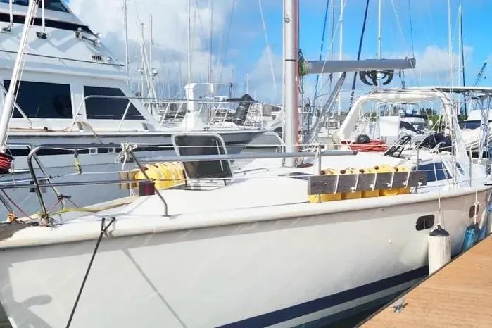 1997 Hunter 430 sailboat docked at marina under clear blue sky.