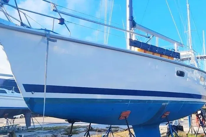 Sailboat Hunter 430, 1997 model, on land with blue and white hull.
